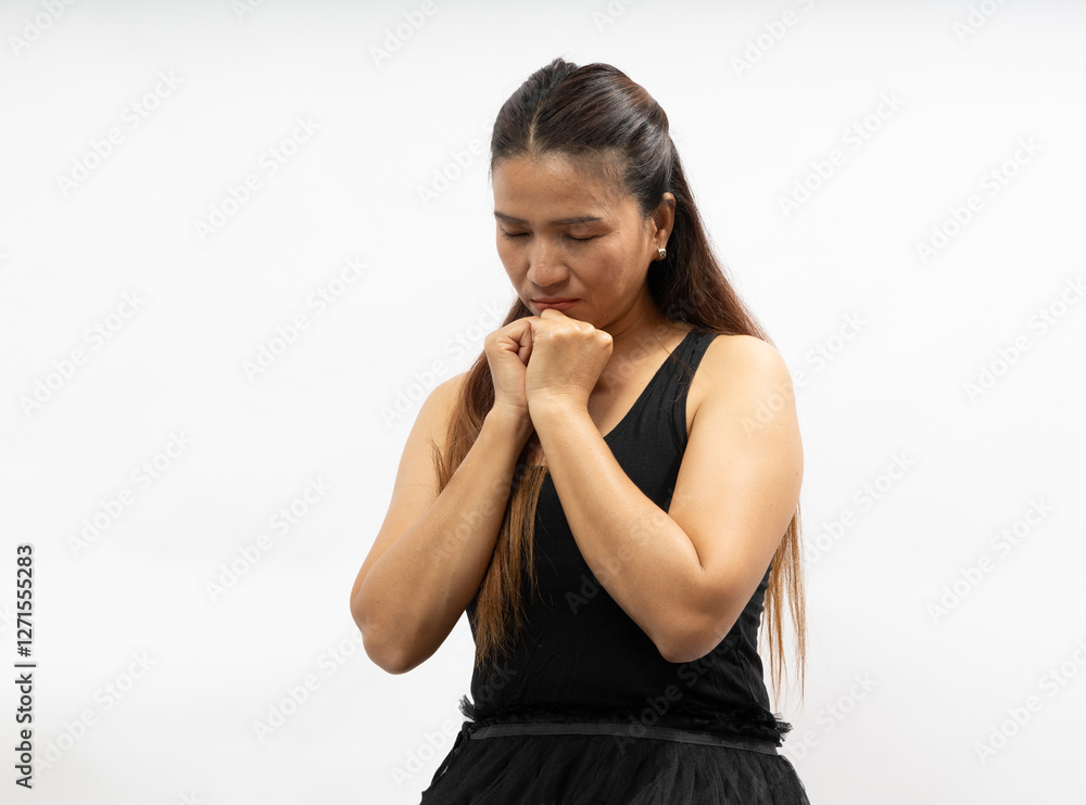 Woman in Black Attire Showing a Thoughtful Expression While Clasping Her Hands Together in a Neutral Background Woman in Black Attire Showing a Thoughtful Expression While Clasping Her Hands Together in a Neutral Background