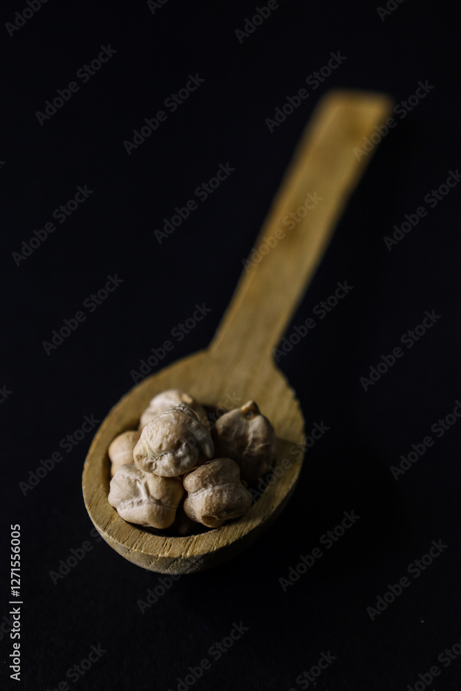 Ceci secchi nel cucchiaino di legno, ricetta tradizionale, legumi, ingredienti freschi Ceci secchi nel cucchiaino di legno, ricetta tradizionale, legumi, ingredienti freschi