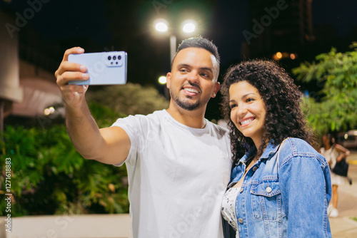 young latin men and women taking a selfie with their phone at night