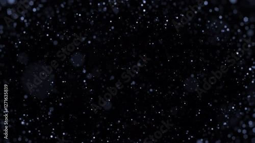 Bokeh of moving floating round particles on a black background