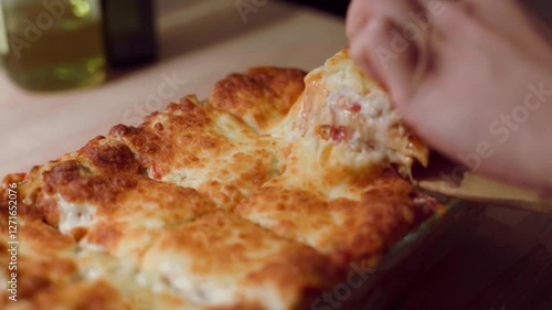 Serving homemade italian lasagna in a slow motion