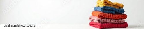 Folded sweater tower in isolation on white surface, white background, knits, stacking clothes