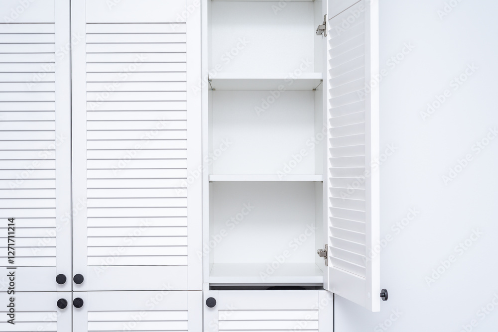 A white wardrobe is built into the wall with black handles A white wardrobe is built into the wall with black handles