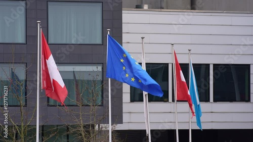 Flags waving at Swiss Airport Zürich Kloten on a gray winter day. Movie shot February 17th, 2025, Zurich Kloten, Switzerland.