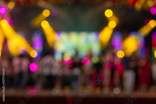 Blurred concert stage with colorful spotlights and crowd in the background