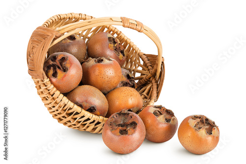 Brown fresh medlars in a wicker basket isolated on white background. Mespilus germanica close-up photo