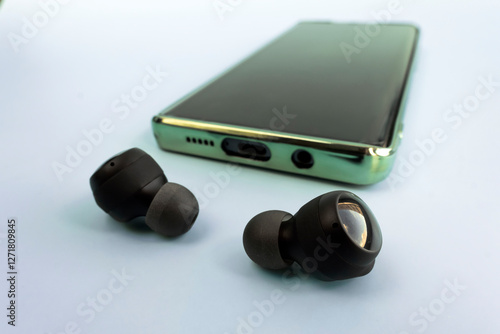 Pair of white wireless earbuds for smartphone on blue background close-up.. Relaxation concept. photo