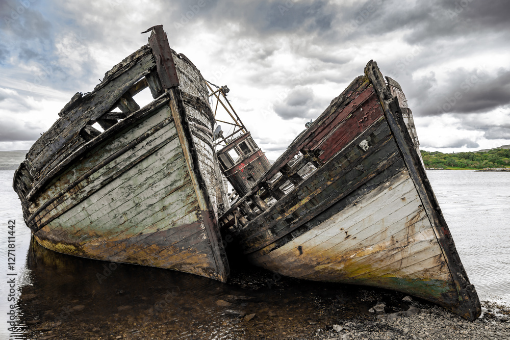 Two abandoned wooden fishing boats in Salen Sound, Isle of Mull, Inner Hebrides, Scotland.These boats have been decaying in the water for over 50 years. Two abandoned wooden fishing boats in Salen Sound, Isle of Mull, Inner Hebrides, Scotland.These boats have been decaying in the water for over 50 years.