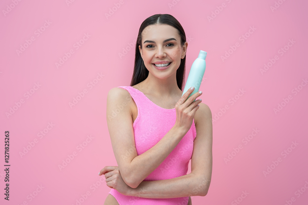 Smiling dark-haired beautiful woman holding a bottle of shampoo Smiling dark-haired beautiful woman holding a bottle of shampoo