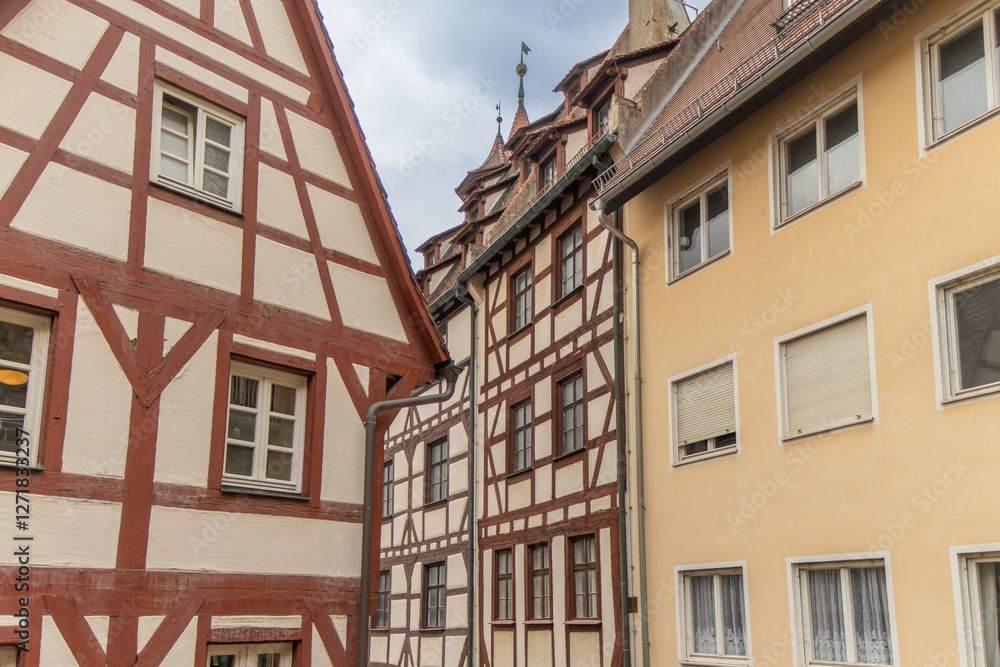 Naklejka premium NUREMBERG, GERMANY. Quaint half timbered houses with red tile roofs and flower boxes. Nuremberg, Germany