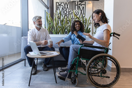 Diverse group of professionals including woman in wheelchair, brainstorming ideas for business