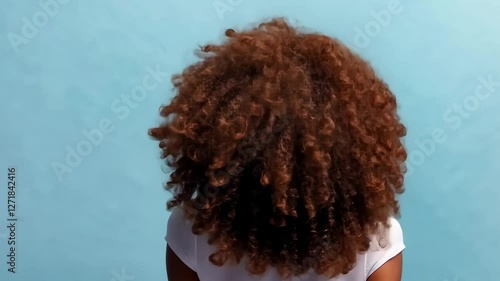 Woman with Afro, back turned, blue backdrop, copy space
