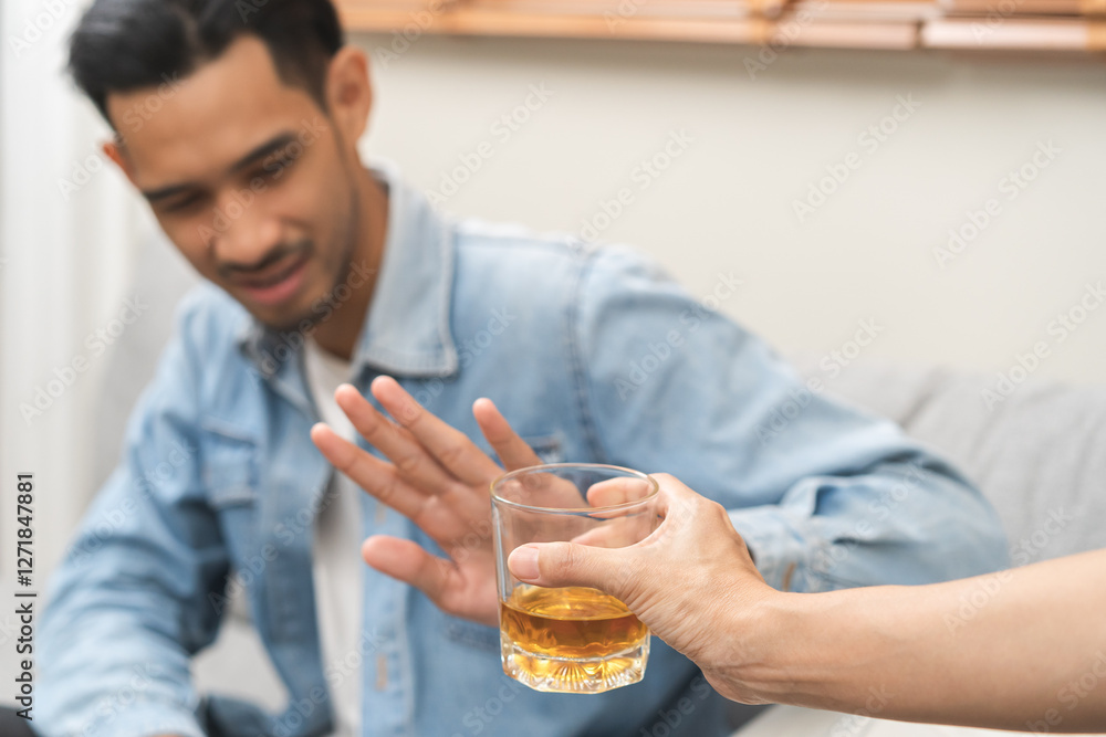 Alcoholism, depressed asian young man refuse, push out alcoholic beverage glass, drink whiskey, sitting alone at night. Treatment of alcohol addiction, having suffer abuse problem alcoholism concept. Alcoholism, depressed asian young man refuse, push out alcoholic beverage glass, drink whiskey, sitting alone at night. Treatment of alcohol addiction, having suffer abuse problem alcoholism concept.