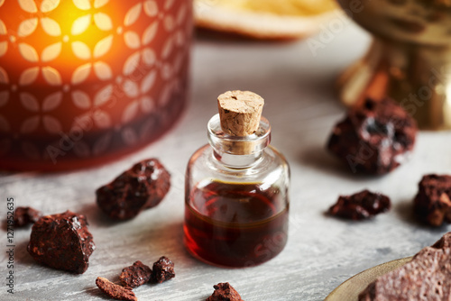 Croton lechleri, or sangre de drago oil on a table with an aroma lamp photo