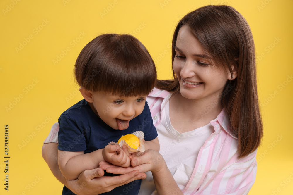 Mother and baby eating tasty mochi on yellow background Mother and baby eating tasty mochi on yellow background