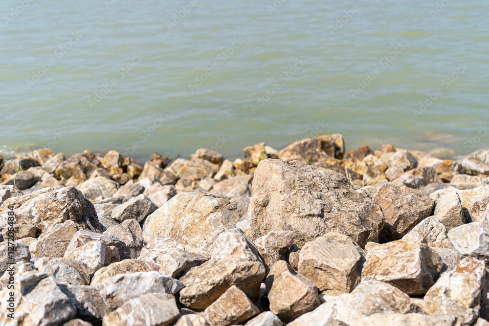 Rocky shoreline with calm water in sunlight. Lake Balaton, Hungary Rocky shoreline with calm water in sunlight. Lake Balaton, Hungary