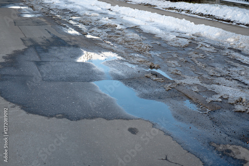 Snow and mud on the side of the road and sidewalk
