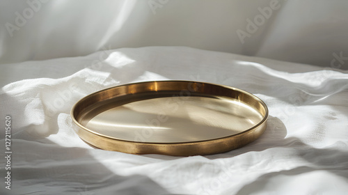 Minimalist golden tray on a white textured surface in natural light casting delicate shadows.