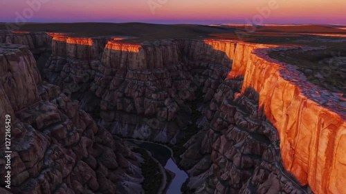 Sunset illuminating rocky canyon landscape with winding river below