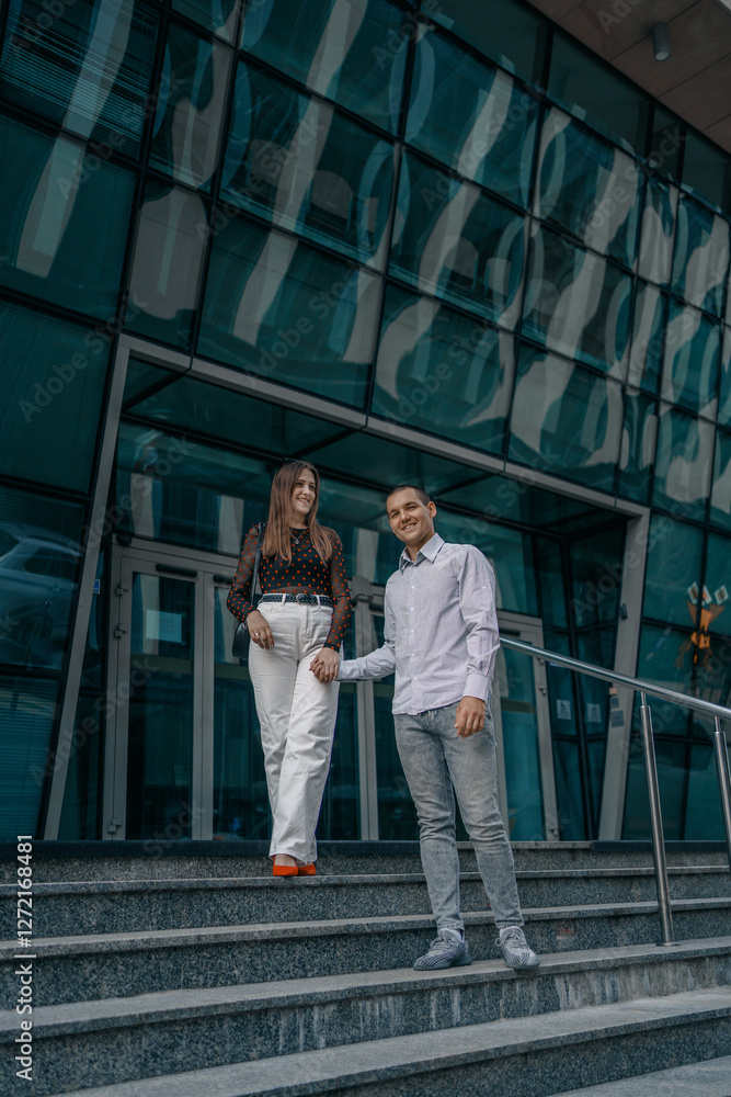 Young couple in love sitting on stairs, talking. Smiling beautiful woman and her handsome boyfriend. Couple in casual summer clothes. Happy cheerful family. Sit at stairs. Young couple in love sitting on stairs, talking. Smiling beautiful woman and her handsome boyfriend. Couple in casual summer clothes. Happy cheerful family. Sit at stairs.