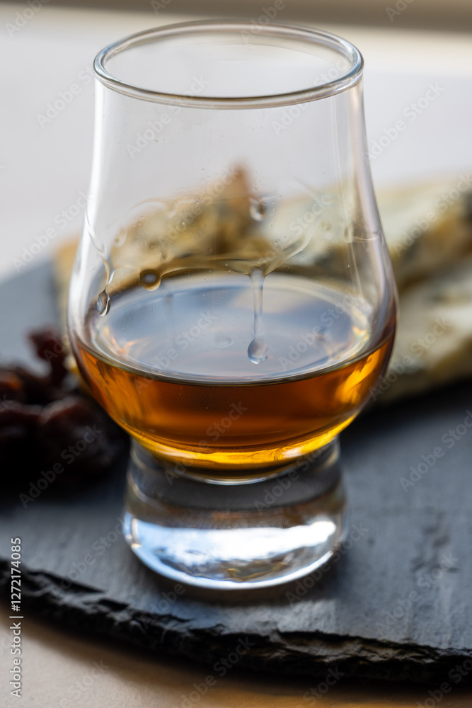 Whiskey and cheese pairing, tasting whisky glass and plate with sliced blue stilton and blue shropshire cheeses, Great Britain food and drink Whiskey and cheese pairing, tasting whisky glass and plate with sliced blue stilton and blue shropshire cheeses, Great Britain food and drink