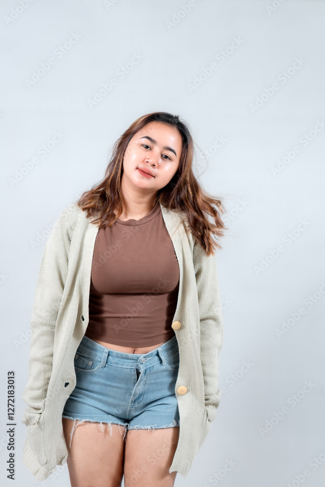 A young woman in a cozy sweater and denim shorts smiles confidently, showcasing a casual and stylish look against a neutral background. A young woman in a cozy sweater and denim shorts smiles confidently, showcasing a casual and stylish look against a neutral background.