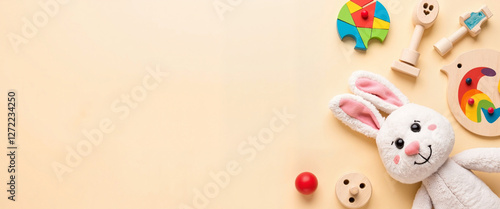 Playful plush bunny and colorful toys on neutral background, childhood joy