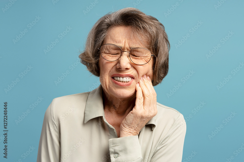 Senior woman is having toothache on blue background Senior woman is having toothache on blue background