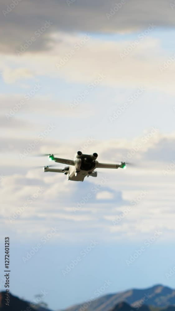 Vertical Video Modern traveler creating content and filming the valley with his drone, climbing on top of a high altitude mountain range. Hiker enjoying the landscape scenery, remote control. Camera B Vertical Video Modern traveler creating content and filming the valley with his drone, climbing on top of a high altitude mountain range. Hiker enjoying the landscape scenery, remote control. Camera B