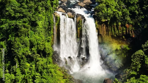 Two- tiered waterfall in mountain forest with rainbow. Limunsudan Falls. Mindanao, Philippines. photo