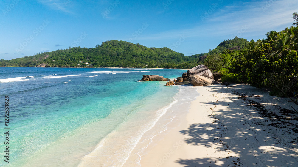 Rocky formations along a pristine beach surrounded by lush green hills. Baie Lazare. Seychelles, Mahe. Rocky formations along a pristine beach surrounded by lush green hills. Baie Lazare. Seychelles, Mahe.