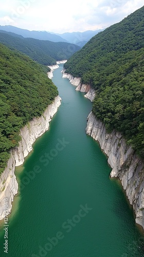 Serene river flowing through lush green mountains under a clear sky
