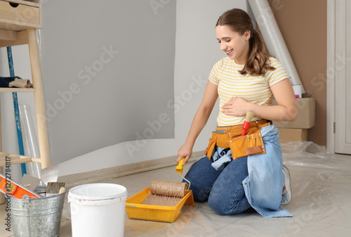 Smiling young woman kneelin...