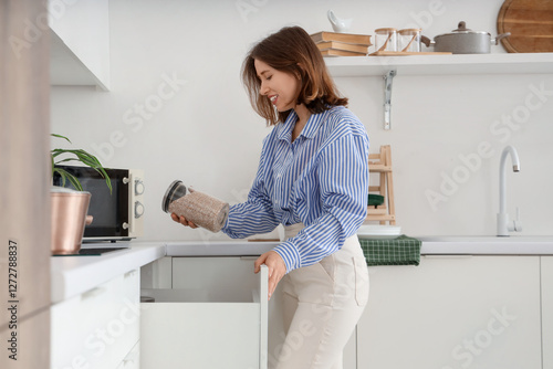 Young woman taking jar of p...