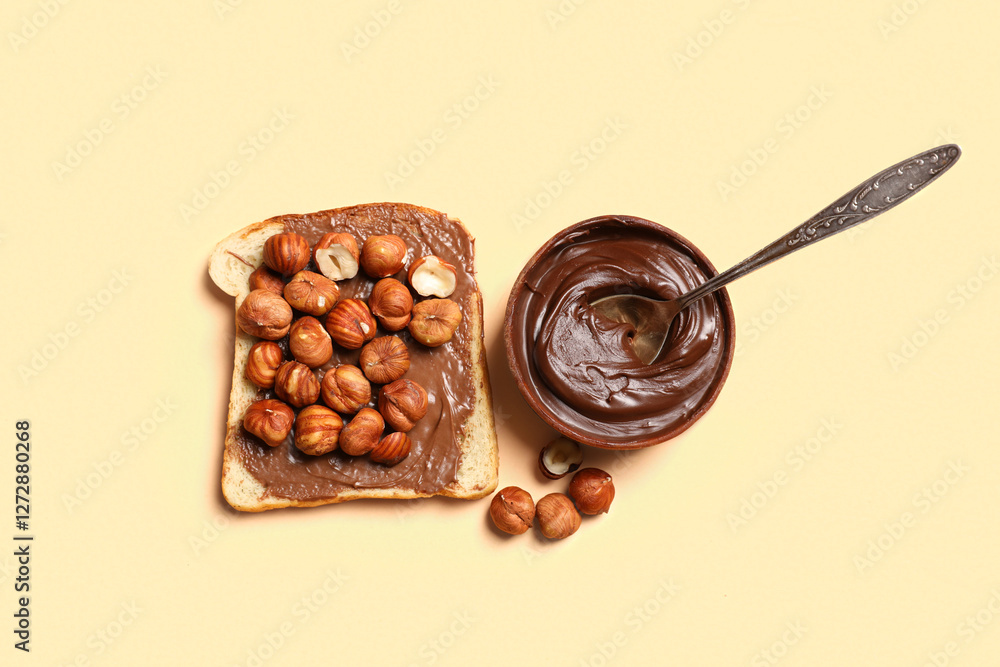 Fototapeta premium Toast with sweet chocolate spread and hazelnuts on orange background