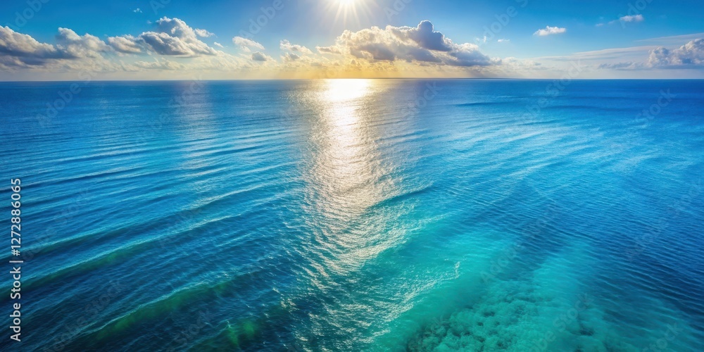 Fototapeta premium Aerial view of a serene blue ocean surface with gentle waves and sunlight on the water , aerial photography, natural beauty