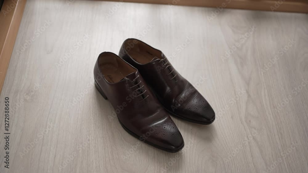Close up of a pair of polished brown leather dress shoes placed on a wooden floor Close up of a pair of polished brown leather dress shoes placed on a wooden floor