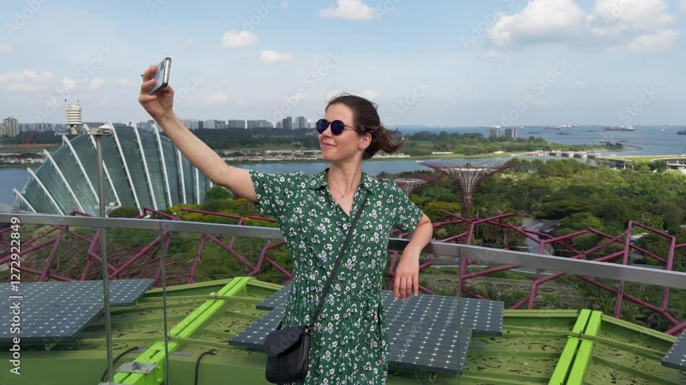 Caucasian woman taking selfie with her phone in the Gardens by the Bay in Singapore, on a sunny day Caucasian woman taking selfie with her phone in the Gardens by the Bay in Singapore, on a sunny day