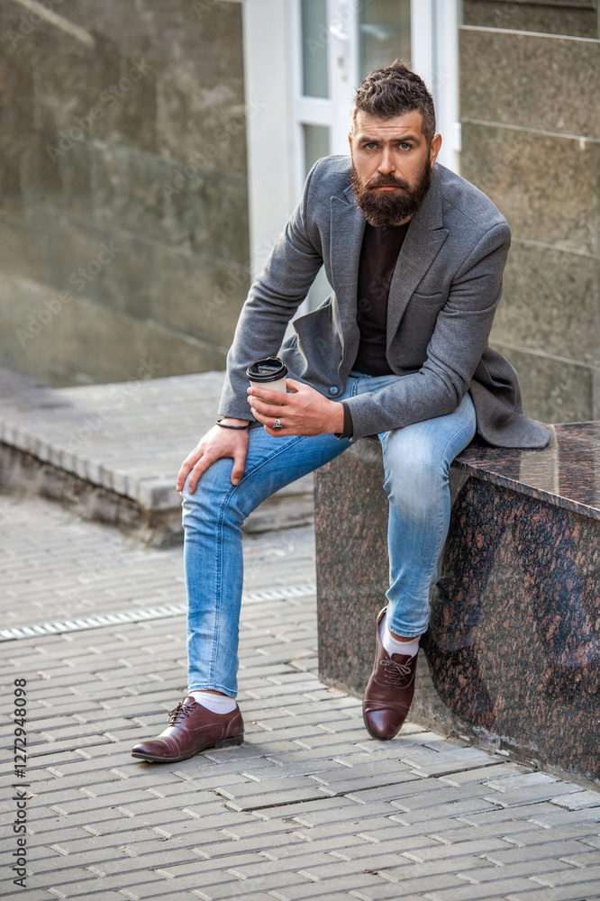 Coffee break. Everyday style routine. Bearded man having coffee in city street. Handsome man on street holding cup of coffee. Business lifestyle, break. Man drinking morning coffee. Male model Coffee break. Everyday style routine. Bearded man having coffee in city street. Handsome man on street holding cup of coffee. Business lifestyle, break. Man drinking morning coffee. Male model