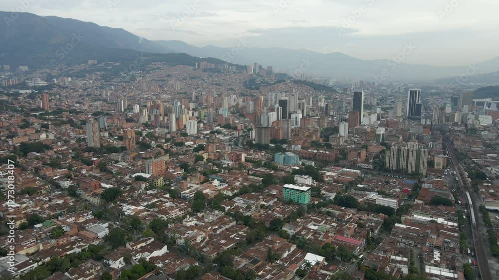 Aerial approach to Medellín highlighting the mix of modern and traditional buildings nestled between hills