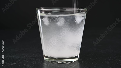 Mixing salt to a glass of water.