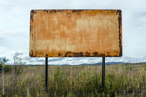 Compact corrugated sign in a rural setting, perfect for agricultural or local business ads. photo