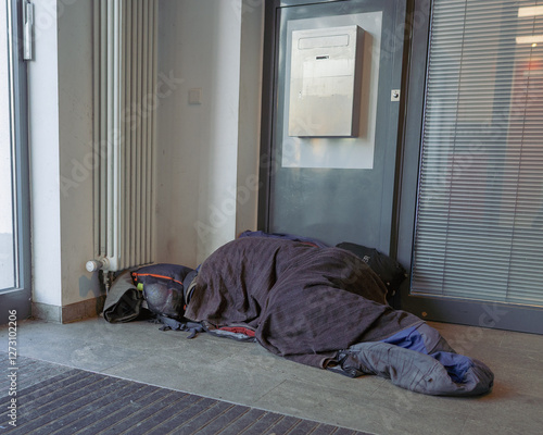 Homeless Person Sleeping in Urban Entranceway photo