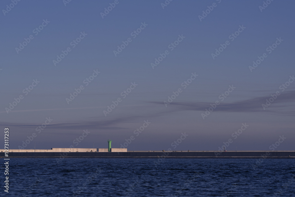 SEA COAST AT DAWN - Harbour breakwater and green navigation sign SEA COAST AT DAWN - Harbour breakwater and green navigation sign