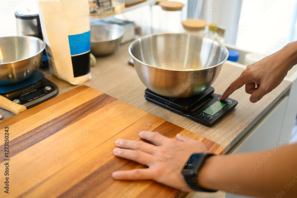 Man measuring ingredients while preparing homemade cookies on countertop Man measuring ingredients while preparing homemade cookies on countertop