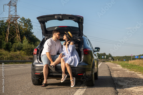 Obraz na płótnie Couple Enjoying a Sunny Day by the Car w salonie
