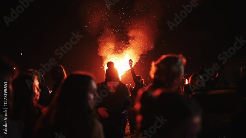 Wallpaper Mural A group of people are gathered around a fire, with some holding cell phones. Scene is lively and social, as people are enjoying each other's company and the warmth of the fire Torontodigital.ca
