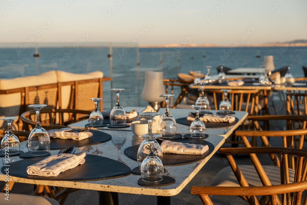 Fototapeta premium Beautifully arranged tables at a seaside restaurant with ocean views