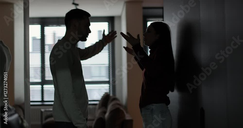 Man and woman shouting at each other, couple quarreling in the evening at home. Husband and wife screaming. Scandal and crisis in family.