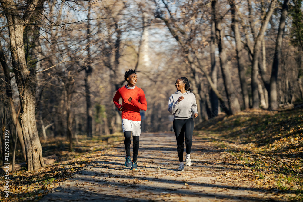 Obraz premium Full length of two interracial sporty friends running in nature towards camera.